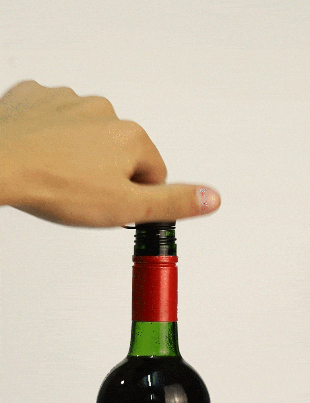 Hand removing the cap from a wine bottle labeled "WOODHAVEN," ready to pour.