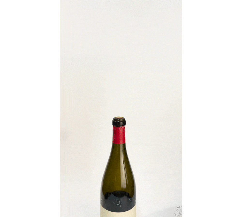 A green wine bottle with a red cap, slowly tipping to pour wine against a plain white background.