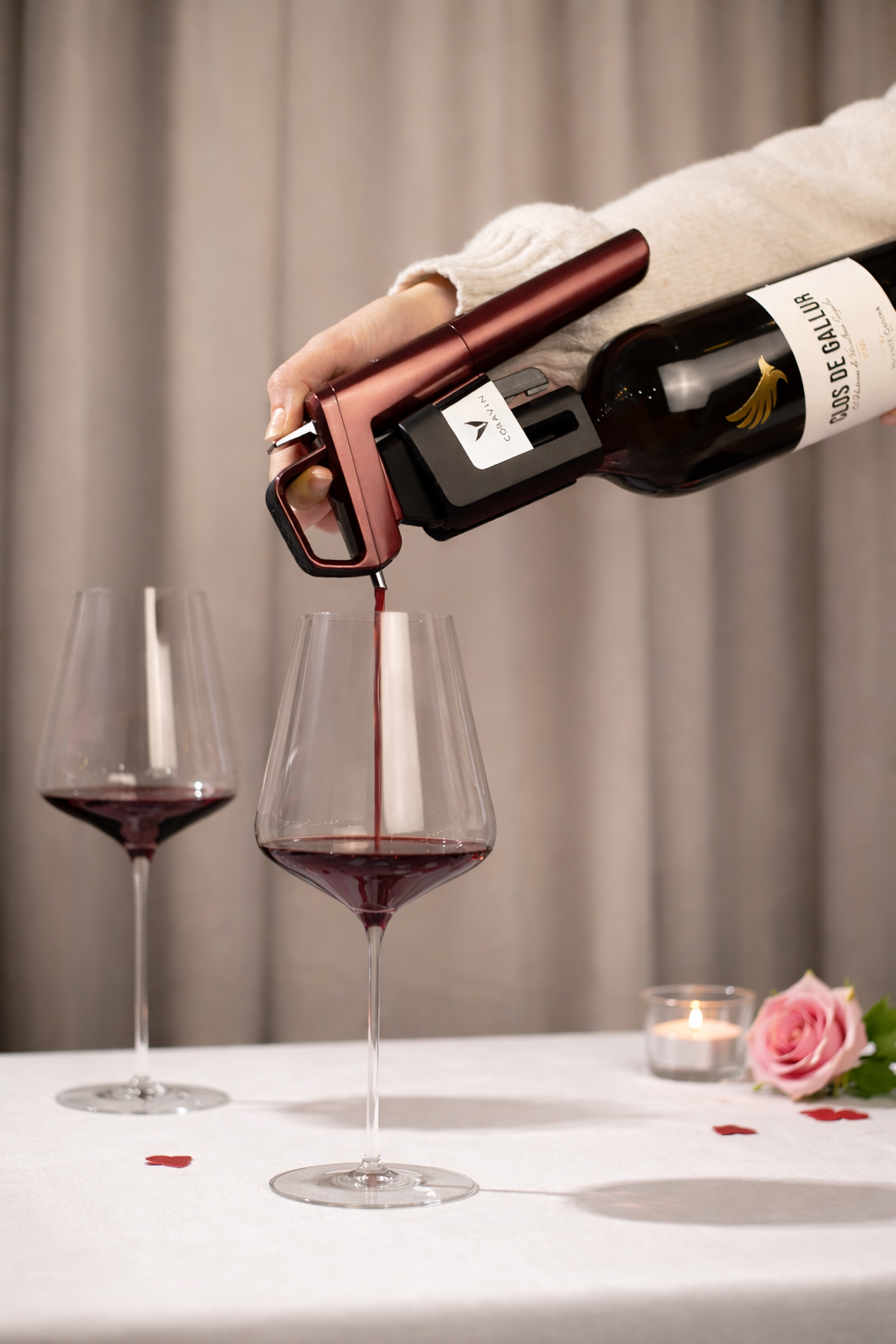 Person pouring red wine into a glass on a table with a neutral background